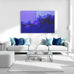 A living room with a white couch and a canvas print featuring an abstract design with purple and blue tones, resembling layered textures.