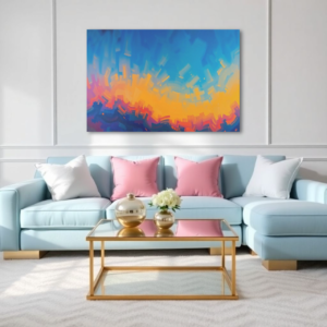 Canvas art featuring a dynamic blend of blue, orange, and pink hues in an abstract sunset scene, displayed above a light blue sofa in a modern living room.