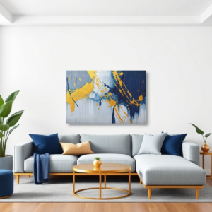 A living room with a gray sectional sofa and a canvas print featuring blue and gold splashes and strokes against a gray background.