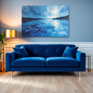 A blue room with a blue sofa and a canvas print featuring a serene sunset over a peaceful coastline with soft waves.